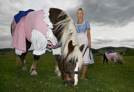 Cosima Scheiding holds a horse dressed in a traditional Bavarian Dirndl costume in the eastern Bavarian village of Kirchberg im Wald, May 5, 2009. Bavarian designer Hildegard Bergbauer, who creates Dirndl dresses for women, also makes and sells Dirndl outfits for home pets and horses.