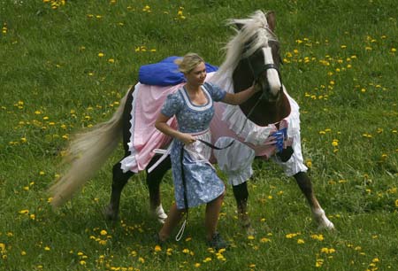 Cosima Scheiding runs with a horse dressed in a traditional Bavarian Dirndl costume in the eastern Bavarian village of Kirchberg im Wald, May 5, 2009. Bavarian designer Hildegard Bergbauer, who creates Dirndl dresses for women, also makes and sells Dirndl outfits for home pets and horses.