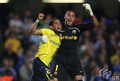 Barcelona's Daniel Alves (L) and goalkeeper Victor Valdes celebrate after the final whistle.