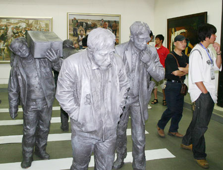 Visitors walk past a group of sculpture exhibited in the 2009 Graduates' Works Show of the Art College of the Nanjing Arts Institute, at the Jiangsu Art Gallery in Nanjing, capital of east China's Jiangsu Province, May 6, 2009. [Xinhua/Xun Hai]