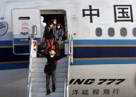 Passengers go off from the chartered plane from Mexico after the plane arrived at Pudong International Airport in Shanghai, east China, May 6, 2009. The chartered plane sent to fetch Chinese citizens from Mexico arrived in Shanghai Wednesday afternoon, with 98 passengers and 21 crew members on board. (Xinhua/Xing Guangli)