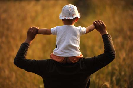 Li Yongbing carries his son Li Zihao in a wheat field in Fuxin Township, Mianzhu City, Sichuan Province, southwest China, May 3, 2009.