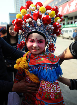 An actress prepares to perform "Beigun", a traditional folk art usually held to pray for harvest and peace, during a folk cultural carnival in Taiyuan, capital of north China