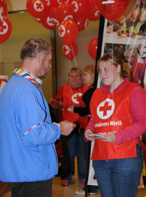 A member of Finnish Red Cross distributes brochures at a shopping mall in Helsinki, Finland, May 6, 2009. May 8 is the World Red Cross Day. Finnish Red Cross held a 6-day campaign that started on Monday to publicize the organization and recruit volunteers.