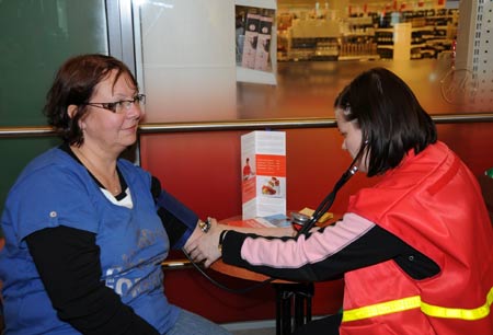 A member of Finnish Red Cross measures blood pressure for a woman at a shopping mall in Helsinki, Finland, May 6, 2009. May 8 is the World Red Cross Day. Finnish Red Cross held a 6-day campaign that started on Monday to publicize the organization and recruit volunteers.