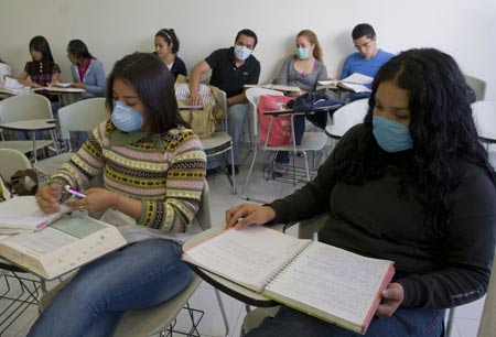 Students wearing masks attend a class at the National Autonomous University of Mexico (NAUM) in the Mexico City May 7, 2009. All high schools and universities in Mexico, suspended classes due to the A/H1N1 flu epidemic, resumed classes on Thursday as the government said the worst of the flu crisis is over. (Xinhua/David De la Paz)