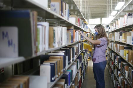 A student wearing a mask browses the bookshelf at the National Autonomous University of Mexico (NAUM) in the Mexico City May 7, 2009. All high schools and universities in Mexico, suspended classes due to the A/H1N1 flu epidemic, resumed classes on Thursday as the government said the worst of the flu crisis is over. (Xinhua) 