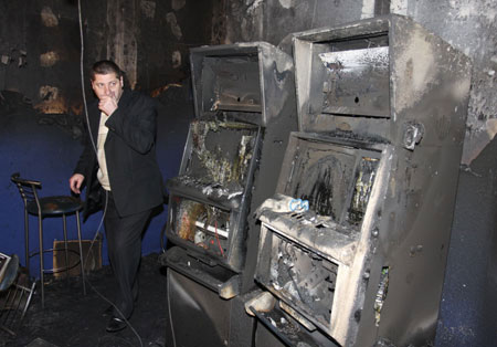 An investigator walks through a gaming hall destroyed by fire in Dnepropetrovsk, May 7, 2009. A fire raced through a gaming hall full of slot machines early on Thursday, killing nine people and injuring 11, the Emergency Ministry said.