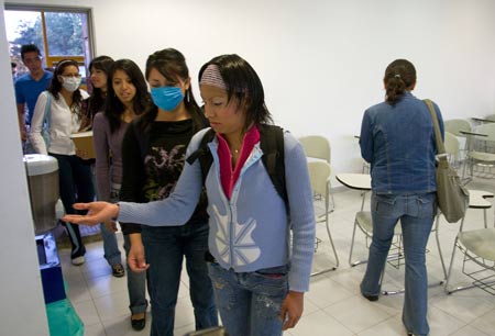 Students spray hand sanitizer before attending classes at the National Autonomous University of Mexico (NAUM) in the Mexico City May 7, 2009. All high schools and universities in Mexico, suspended classes due to the A/H1N1 flu epidemic, resumed classes on Thursday as the government said the worst of the flu crisis is over. (Xinhua/David De la Paz) 