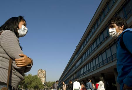 Two students wearing masks greet each other at the National Autonomous University of Mexico (NAUM) in the Mexico City May 7, 2009. All high schools and universities in Mexico, suspended classes due to the A/H1N1 flu epidemic, resumed classes on Thursday as the government said the worst of the flu crisis is over. (Xinhua/David De la Paz) 