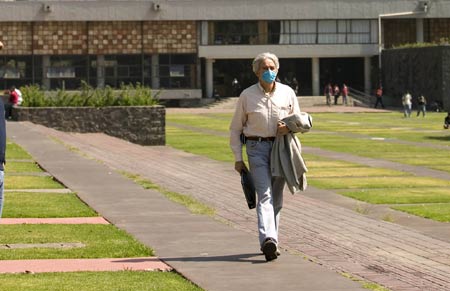 A teacher wearing a mask walks in the National Autonomous University of Mexico (NAUM) in the Mexico City May 7, 2009. All high schools and universities in Mexico, suspended classes due to the A/H1N1 flu epidemic, resumed classes on Thursday as the government said the worst of the flu crisis is over. (Xinhua)