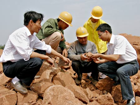 Working staff of the Nankang Museum inspect a construction site where dinosaur egg fossils were found in Nankang, east China's Jiangxi Province, May 6, 2009. Some 22 round dinosaur egg fossils, with the diameter of 10-12 centimeters, were found here recently. (Xinhua/Xu Chaoyang)