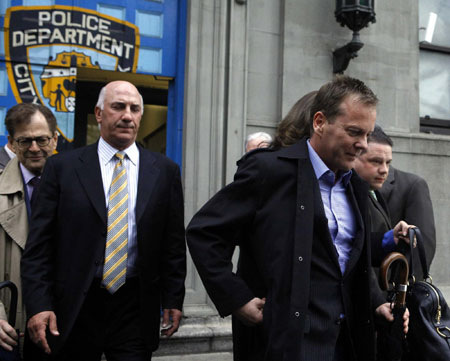 Actor Kiefer Sutherland (R) departs the New York Police Department's 1st precinct in New York May 7, 2009. TV star Sutherland was arrested by New York police on Thursday and charged with assault for headbutting another man.