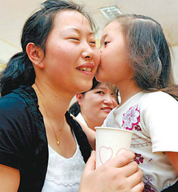 A girl presents her mother with a paper cup on which she had drawn a heart and also a kiss at an event on Friday to mark Mother's Day at a kindergarten in Hefei,Anhui province. [Jie Chen] 