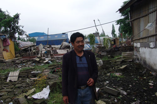 Earthquake victim Li Chuanfu, is interviewed in front of his collapsed house in Hanwang, Sichuan Province, on May 9.