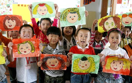 Kids show their drawings of their mothers, at Yixiu kindergarten in Suzhou, east China's Jiangsu Province, May 8, 2009, to celebrate the Mother's Day, which falls on May 10 this year. [Xinhua]