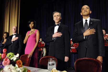  US President Barack Obama (L) and first lady Michelle Obama (C) stand with members of the head table for the national anthem at the White House Correspondents' Association Dinner in Washington, May 9, 2009. Also pictured are entertainer Wanda Sykes (L), New York Times photographer Doug Mills (2nd L) and Associated Press President Tom Curley (2nd R). [Xinhua/Reuters]