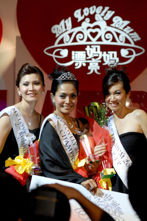 Nordaliya (C) poses with the runner-up Hew Pin Yik (R) and the 2nd runner-up Tai Yen Tiang (L) after she won the champion during 'My Lovely Mum' contest in Serdang of Selangor State, Malaysia, May 10, 2009. A shopping mall held the contest to celebrate the Mother's Day. [Chong Voon Chung/Xinhua]