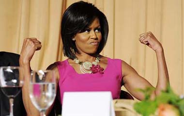 U.S. first lady Michelle Obama flexes her arms in response to a joke about her habit of wearing sleeveless dresses during the White House Correspondents' Association Dinner in Washington May 9, 2009.[Xinhua/Reuters]