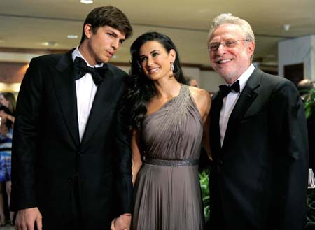 Hollywood couple actress Demi Moore (C) and actor Ashton Kutcher (L) pose with CNN newsman Wolf Blitzer upon their on arrival on the red carpet for the annual black-tie White House Correspondents Dinner, at the Washington Hilton, in Washington, May 9, 2009.[Xinhua/Reuters] 