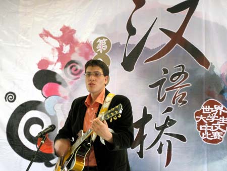 A contestant sings a Chinese song during the French round of the 'Chinese Bridge' competition, a Chinese-language proficiency contest for foreign college students, in Poitiers, France, on May 9, 2009. The two winners of the contest held here on Saturday will attend the final of the 'Chinese Bridge' competition, which would be held this July in Changsha, central China's Hunan Province. [Li Xuemei/Xinhua]