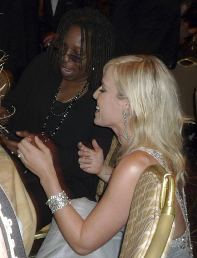 Actress and comedian Whoopi Goldberg (L) and singer Natasha Bedingfield (R) look at Goldberg's mobile phone together at the White House Correspondents Association Dinner in Washington May 10, 2009.