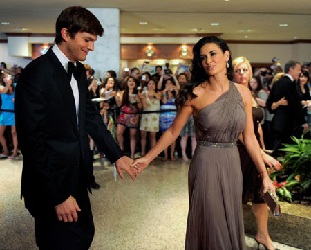 Actress Demi Moore holds hands with her husband actor Ashton Kutcher as they pass photographers upon their arrival on the red carpet for the annual black-tie White House Correspondents Dinner in Washington May 9, 2009. 