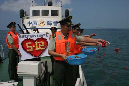 Soldiers spread flower leaves to the sea in commemoration of the victims of the May 12 earthquake last year, during an activity in Sanya, south China&apos;s Hainan Province, May 11, 2009. As the first anniversary of the earthquake approaches, people all over China commemorate the disaster in different ways.[Xinhua]