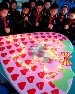 Pupils mourn the victims of the May 12 earthquake last year, during an activity at Daminghu Primary School in Jinan, capital of east China&apos;s Shandong Province, May 11, 2009. As the first anniversary of the earthquake approaches, people all over China commemorate the disaster in different ways.[Xinhua]