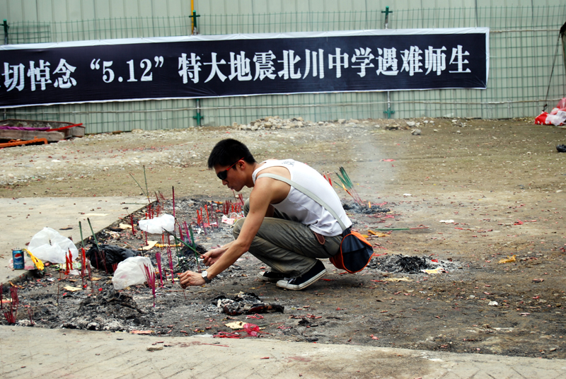 A young man pays his respects at Beichuan Middle School on May 11, 2009 As the first anniversary of May 12 Sichuan earthquake approaches, people all over China commemorate the disaster in different ways.[[John Sexton, China.org.cn]