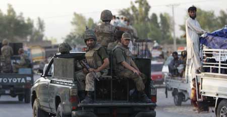 Soldiers pass fleeing civilians on the border of Malakand and Mardan districts of Pakistan's North West Frontier Province, about 150 km (85 miles) north west of Islamabad May 10, 2009.[Xinhua/Reuters]