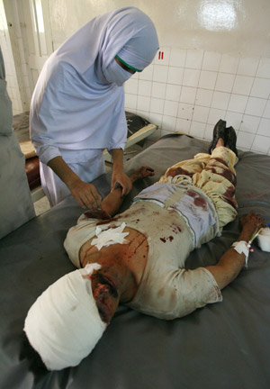 A nurse treats a bomb victim at a hospital in Peshawar, located in Pakistan's North West Frontier Province, May 11, 2009. A suicide car-bomber killed 10 people at a security checkpost in northwest Pakistan on Monday as the army battled Taliban militants in the Swat valley. [Xinhua/Reuters]