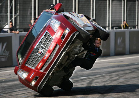 A stunman clings to the bottom of a surfing car as the 11-membered Hollywood team performs vehicular stunts at Shanghai F1 International Circuit Saturday May 9, 2009. Car surfing is the act of riding outside of a vehicle while it is moving.[Xinhua]