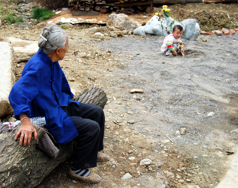 An old lady looks at a baby boy, possibly her great-grandson, in Beichuan on May 11, 2009. [John Sexton/China.org.cn]