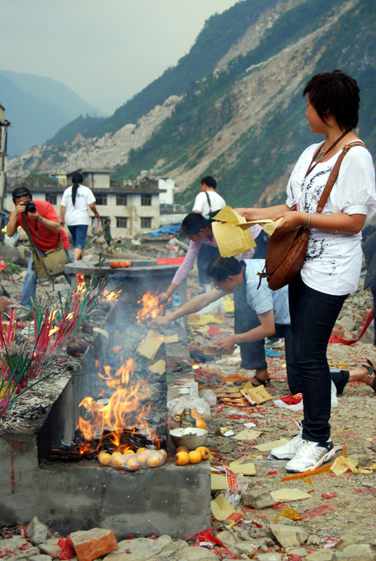 A woman burns paper money in Beichuan on May 11, 2009. [John Sexton/China.org.cn]