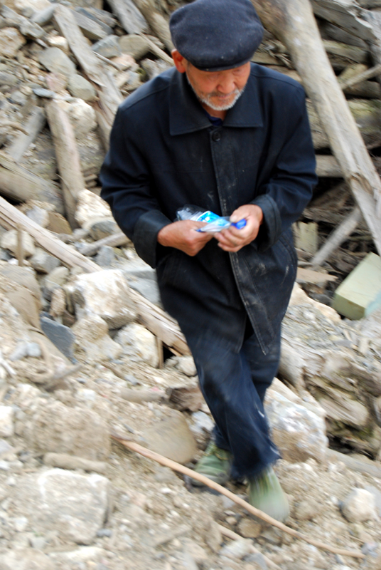 An old man collects plastic bottles in the ruins of Beichuan on May 11, 2009. [John Sexton/China.org.cn]