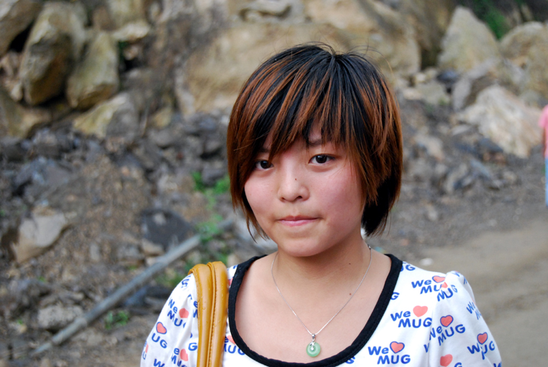 A young woman who lost her mother in the earthquake returns to her former home in Beichuan on May 11 2009. [John Sexton/China.org.cn]