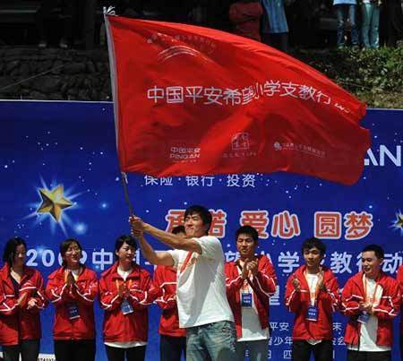 Chinese hurdler Liu Xiang waves a flag at a primary school in quake-hit Beichuan county, southwest China's Sichuan province, Monday May 11, 2009. [Xinhua]