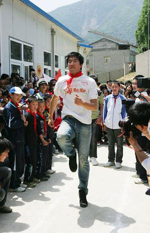 Chinese hurdler Liu Xiang shows quake zone pupils how to hurdle at a primary school in Beichuan county, southwest China's Sichuan province, Monday May 11, 2009. [Xinhua]