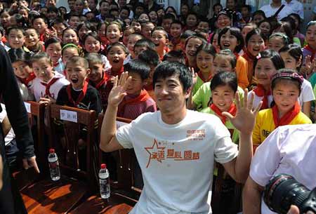  Chinese hurdler Liu Xiang poses for photgraphs with quake zone pupils at a primary school in Beichuan county, southwest China's Sichuan province, Monday May 11, 2009. [Xinhua]