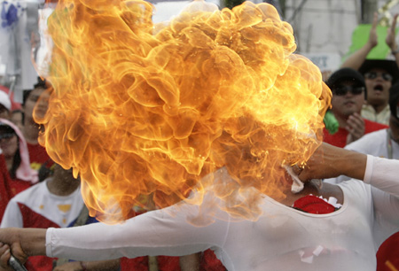 A fire-eater entertains the crowd at a street procession honouring Saint Roque, a miracle worker and the patron saint of the unmarried, in Valenzuela City, north of Manila May 12, 2009. 