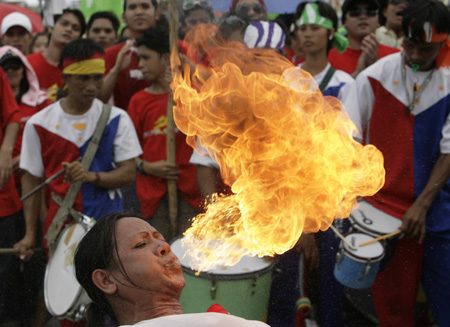 A fire-eater entertains the crowd at a street procession honouring Saint Roque, a miracle worker and the patron saint of the unmarried, in Valenzuela City, north of Manila May 12, 2009. 