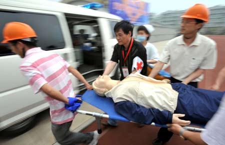 People take part in a quake rescue drill at Jingcheng Experimental School in Hangzhou, capital of Zhejiang Province in east China, May 12, 2009, China's first National Disaster Prevention and Reductin Day on the occasion of the first anniversary of the May 12, 2008 Wenchuan earthquake.[Xinhua]