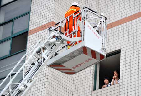 Students take part in a quake rescue drill at Jingcheng Experimental School in Hangzhou, capital of Zhejiang Province in east China, May 12, 2009, China's first National Disaster Prevention and Reductin Day on the occasion of the first anniversary of the May 12, 2008 Wenchuan earthquake.[Xinhua]