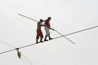 Alfred Nock Junior (R) of Switzerland helps Ya Kefujiang Maimitili of China after Ya dropped his bar during the speed race of the 2009 Hangang High Wire World Championship in Seoul, in which participants cross the Han River on a 1 km (0.62 miles) wire, May 10, 2009. A total of 20 high-wire walkers from 12 countries participated in the event which is part of the annual 'Hi Seoul Festival' organised by Seoul City.[Jo Yong-Hak/REUTERS/CCTV/SOUTH KOREA SOCIETY] 