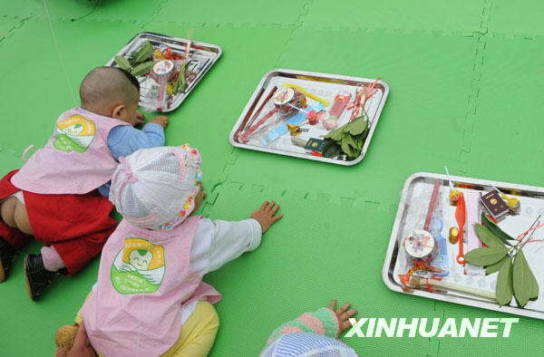 Babies grab lots at a school in Shifang city, southwest China's Sichuan Province, May 13, 2009. 