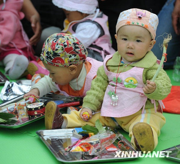 Babies grab lots at a school in Shifang city, southwest China's Sichuan Province, May 13, 2009. 