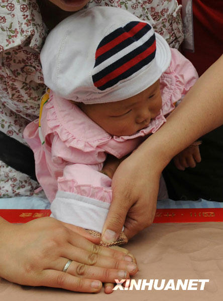 A baby is helped make a hand clay model during a vocational inclination test ceremony for the 'earthquake babies ' at a school in Shifang city, southwest China's Sichuan Province, May 13, 2009. 