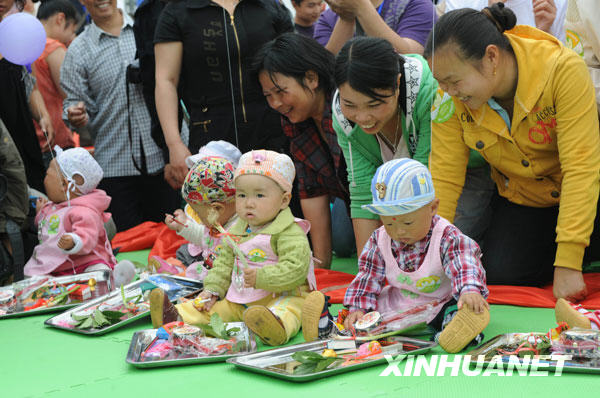 Babies grab lots at a school in Shifang city, southwest China's Sichuan Province, May 13, 2009. The Luohan (Arhat) Temple in Shifang took in all the lying-in pregnant women as the neighbouring Maternal and Child Care Service Center of Shifang was dilapidated by the earthquake on May 12, 2008. 