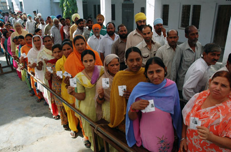 Voters show their identity cards before casting their vote at a polling booth in Amritsar, India, on May 13, 2009. India voted in the final phase of its marathon five-phase general elections Wednesday with 107 million voters eligible to exercise their franchise.[Xinhua]